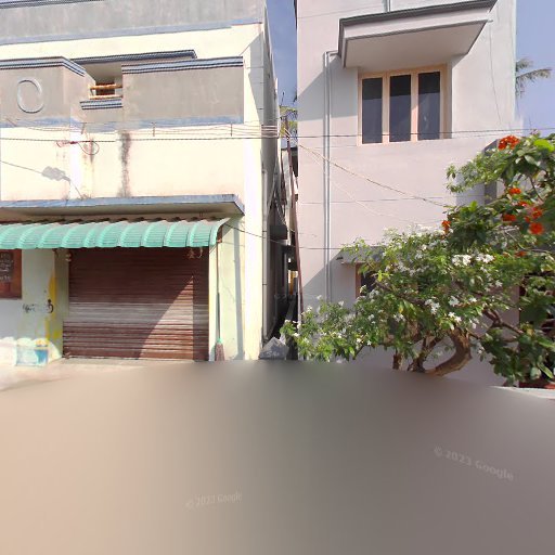 Two-story building with a closed garage, green awning, and adjacent flowering tree on a sunny street.